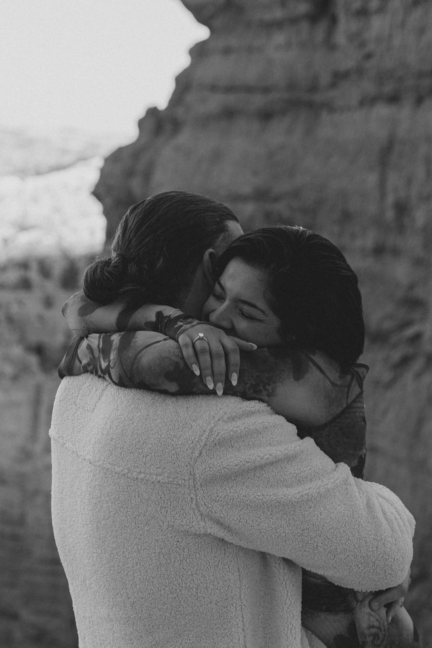 An intimate black and white embrace against dramatic desert canyon walls.