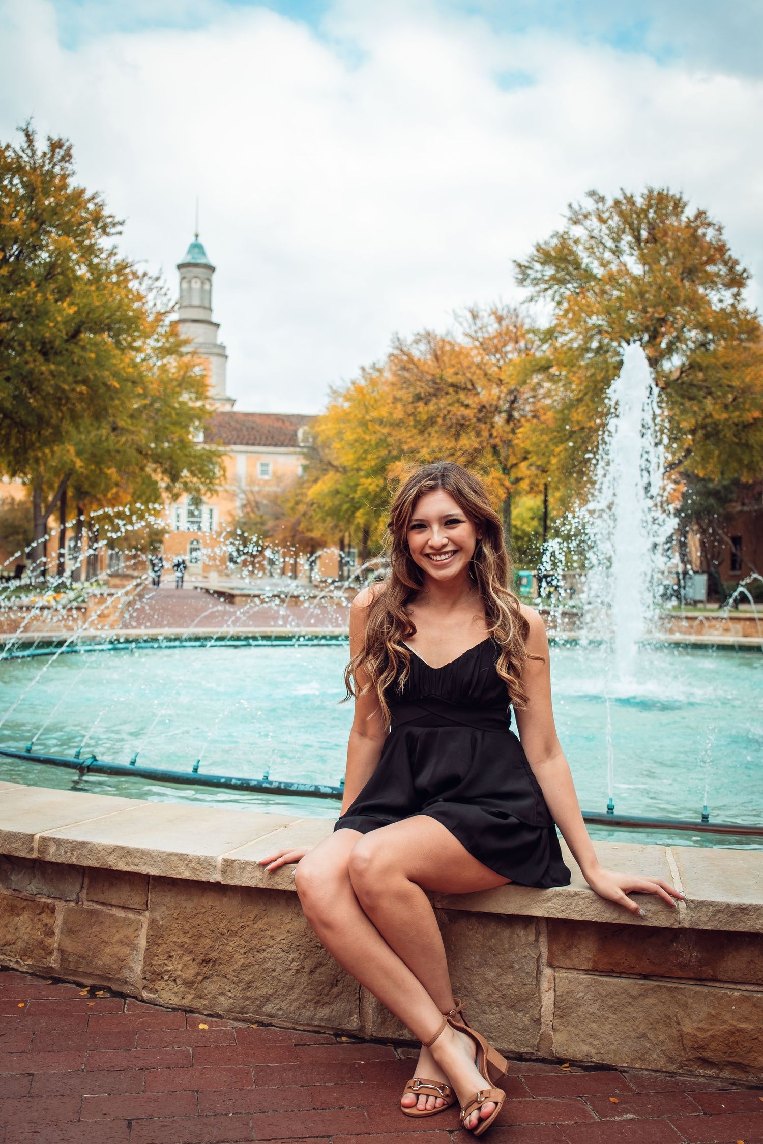 Portrait of UNT Graduate sitting next to a fountain, captured by Eric Aaberg Photography (#1 UNT grad photographer).