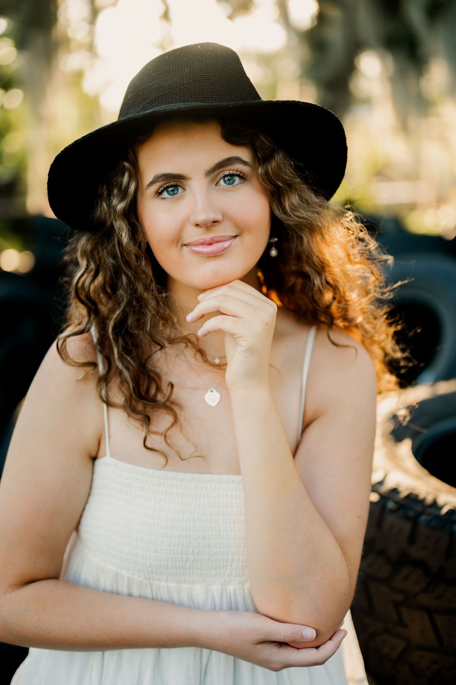 Stylish portrait featuring woman in black hat and white dress.