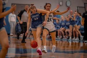 Basketball players from opposing teams compete for the ball during a fast-paced game.