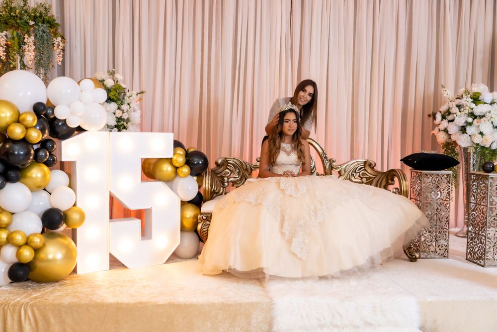 Festive party scene with gold balloons, lit-up letters, and elegant decorations.
