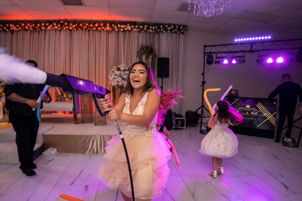 Dancing celebration with fog effects and purple lighting at wedding reception.