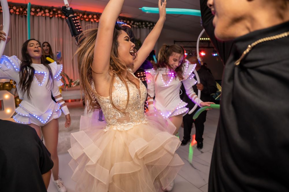 Energetic dancing and celebration on wedding reception dance floor with festive lighting.
