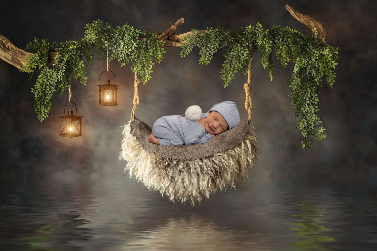 Ethereal newborn portrait in suspended nest with hanging lanterns and green foliage over water.