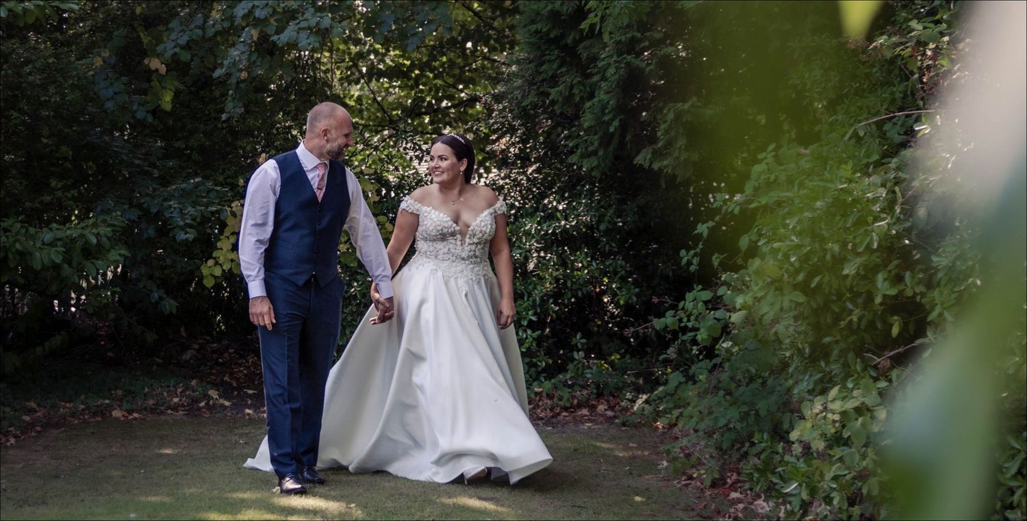 Elegant wedding photography beneath lush green garden foliage.