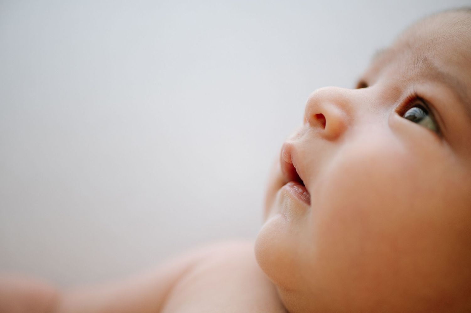 Close-up portrait of baby's face looking up with wonder.