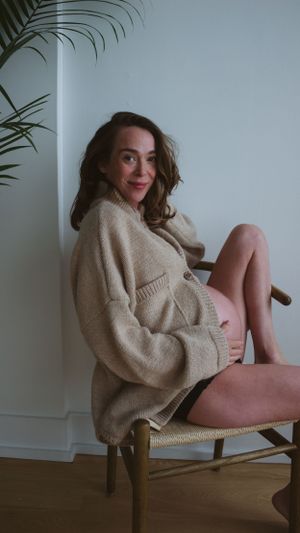 indoors maternity photos with cozy sweater and bump showing
