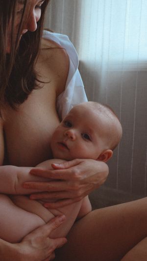 Intimate breastfeeding motherhood session with six months old baby