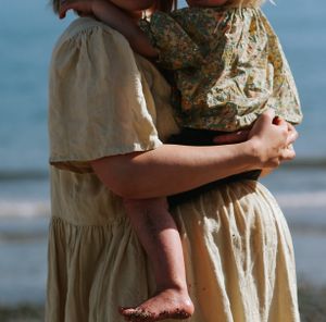 The softest moment between a toddler girl and her pregnant mom during an outdoor documentary-style family photoshoot.