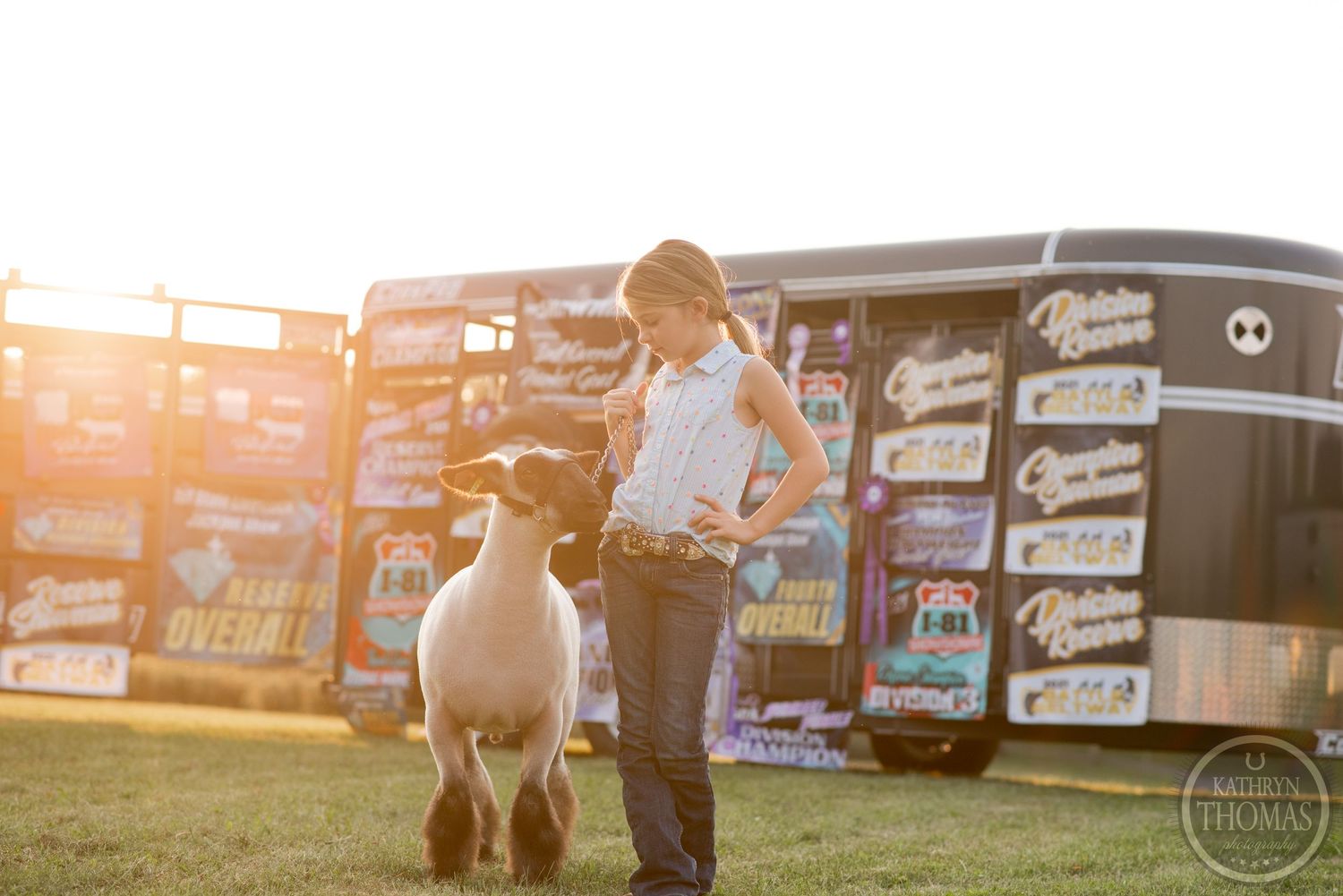 Show lamb and handler pose together during golden hour with banner wall backdrop.