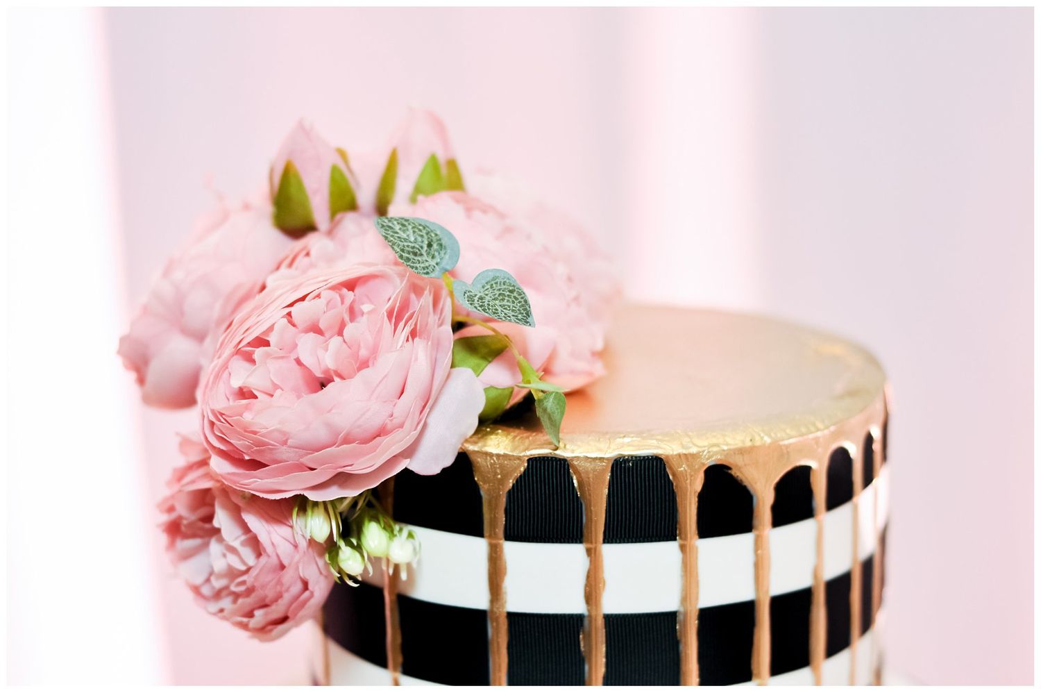 close up of black and white cake with pink flower