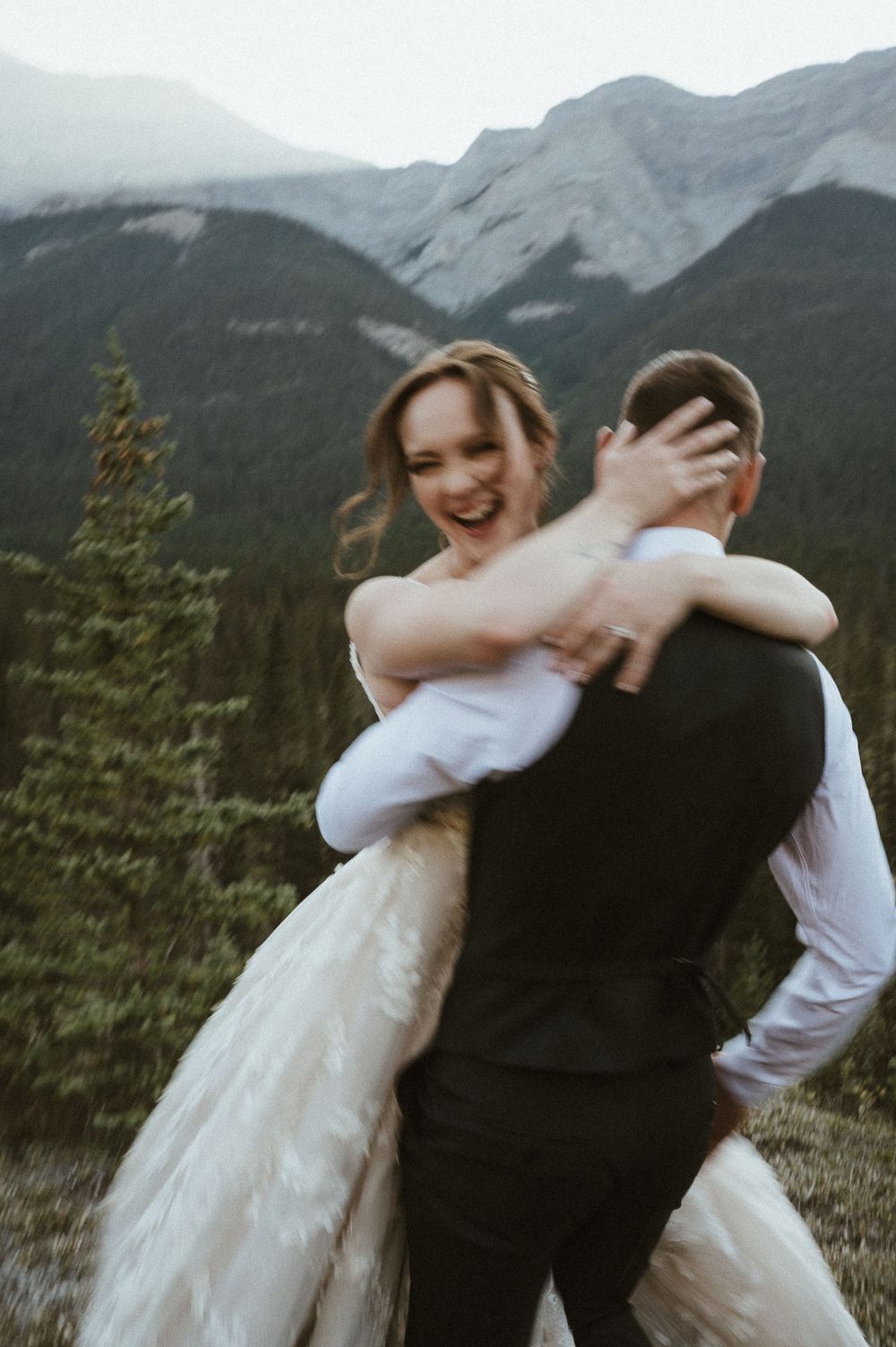 A joyful wedding moment with snow-capped mountains creating a stunning backdrop.