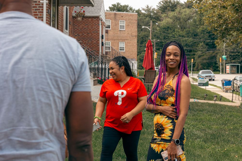 People gathered outdoors near brick buildings during a casual community event.