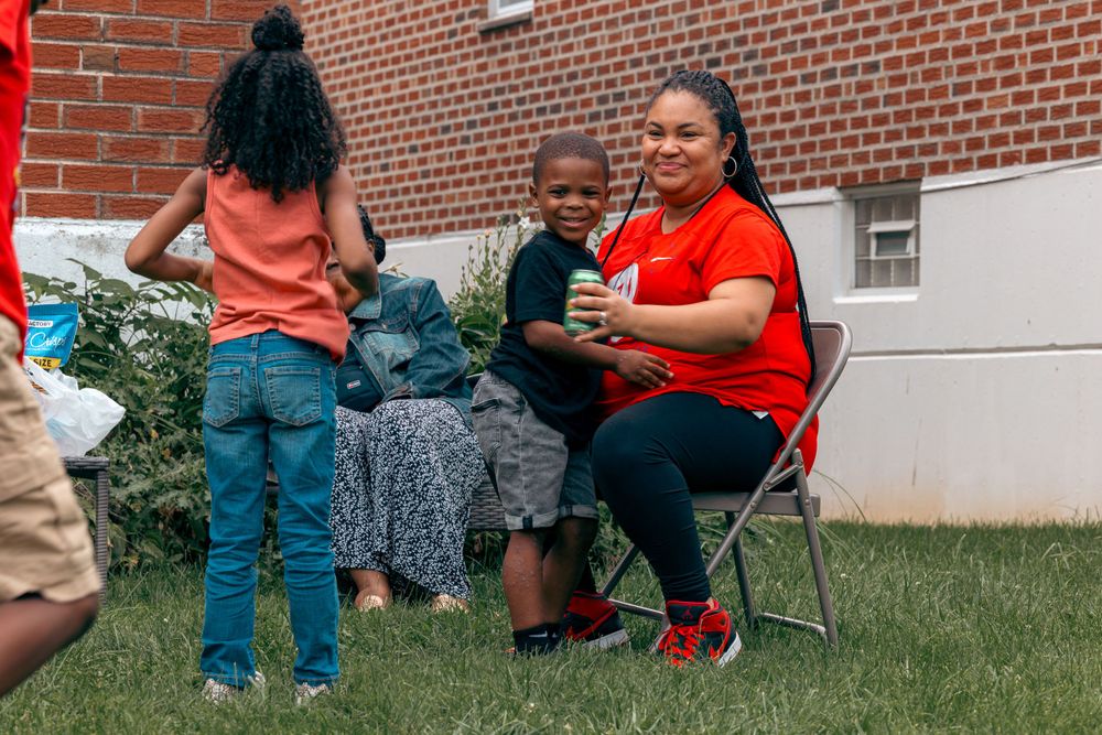 People relaxing and socializing on lawn chairs during an outdoor community event.