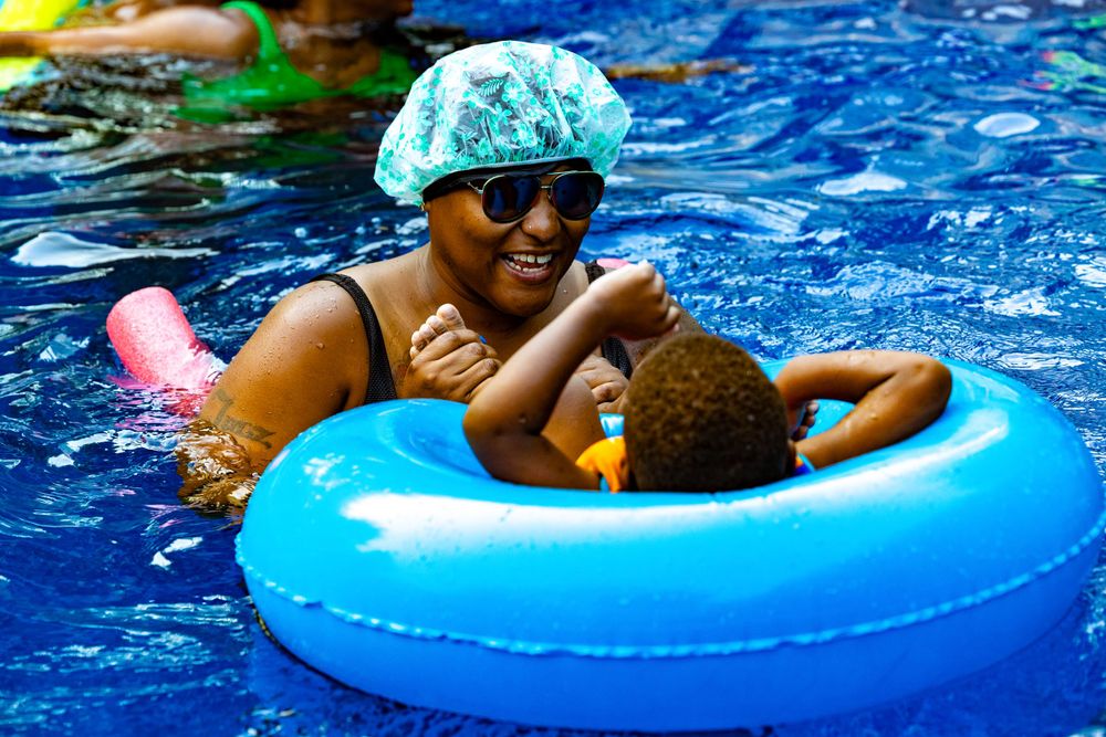 People relaxing in blue inner tubes floating in a pool on a sunny day.