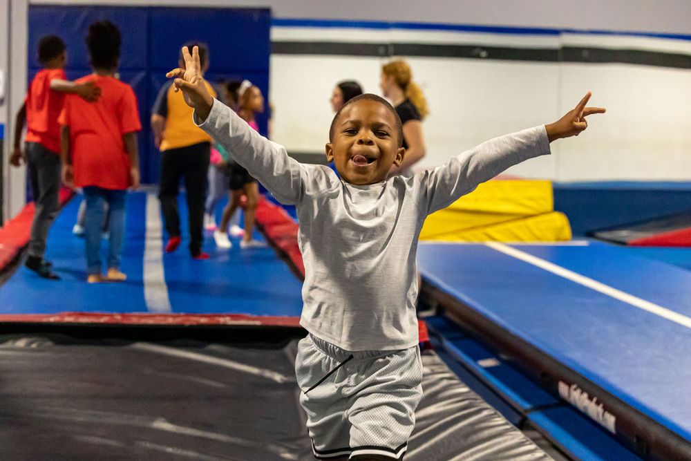 Kids jumping and playing on a trampoline in an indoor sports facility.