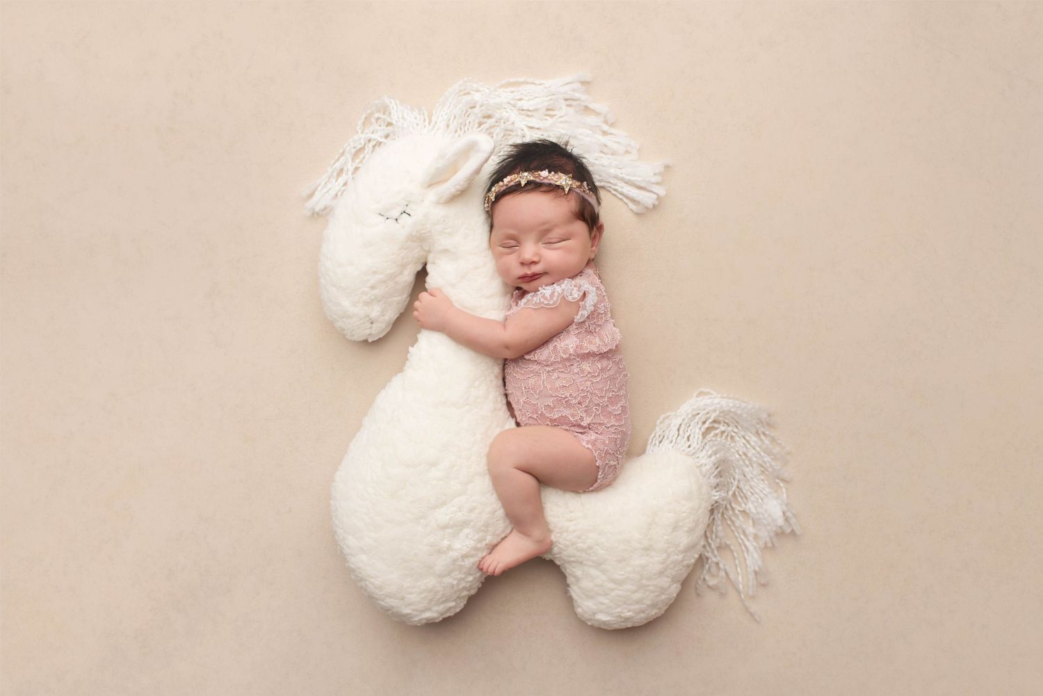 baby girl on unicorn pillow