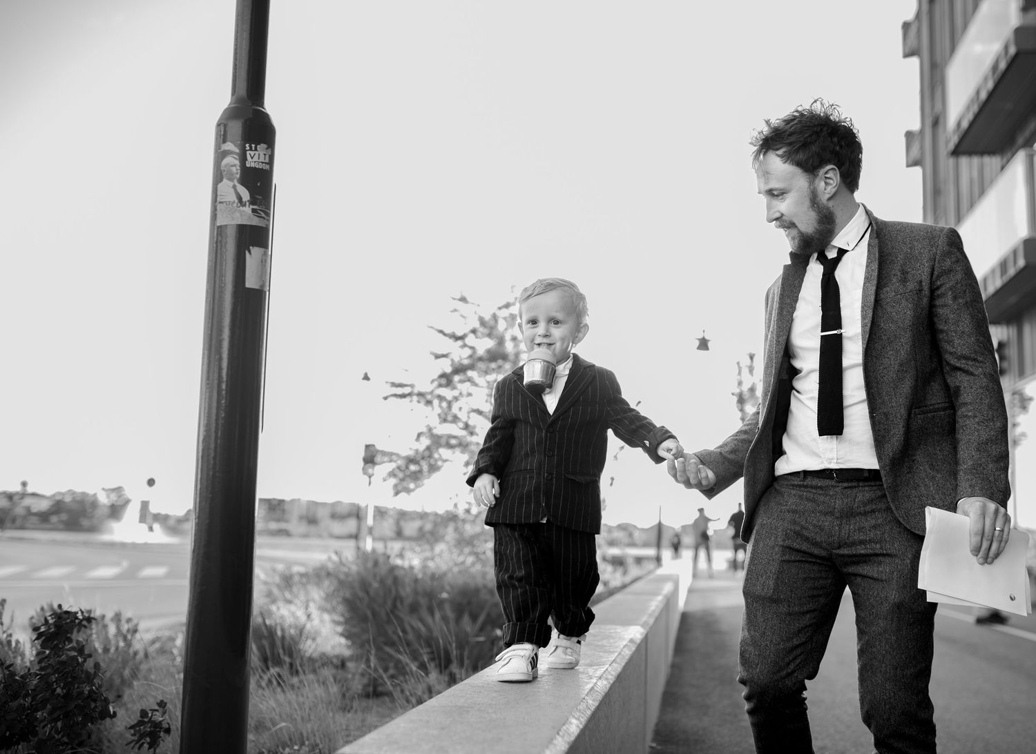 Black and white portrait of walking along urban wall.
