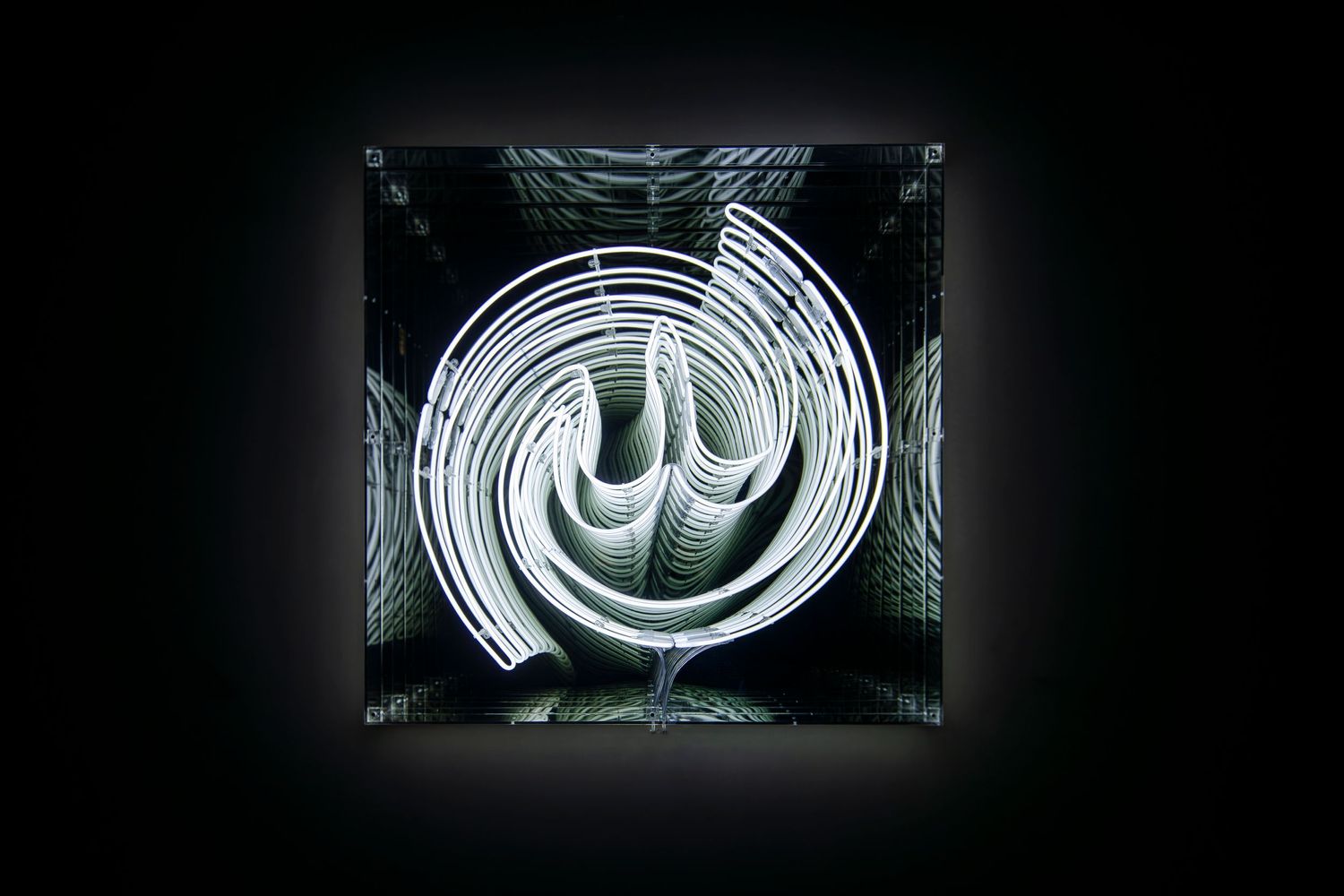 White neon Arabic calligraphy art installation displayed in a dark frame.