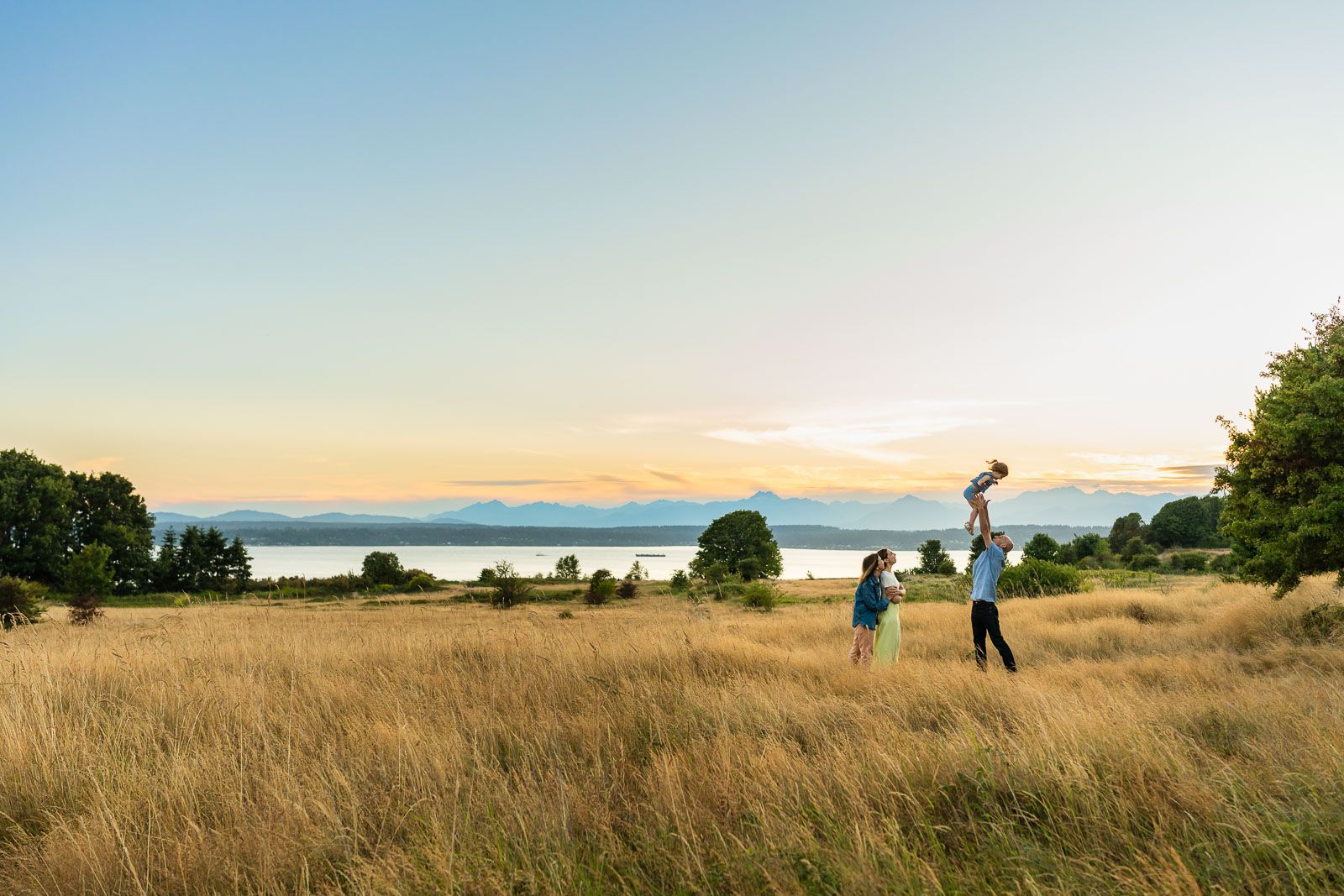 Father throwing daughter in the air at the bluff at Discovery Park.