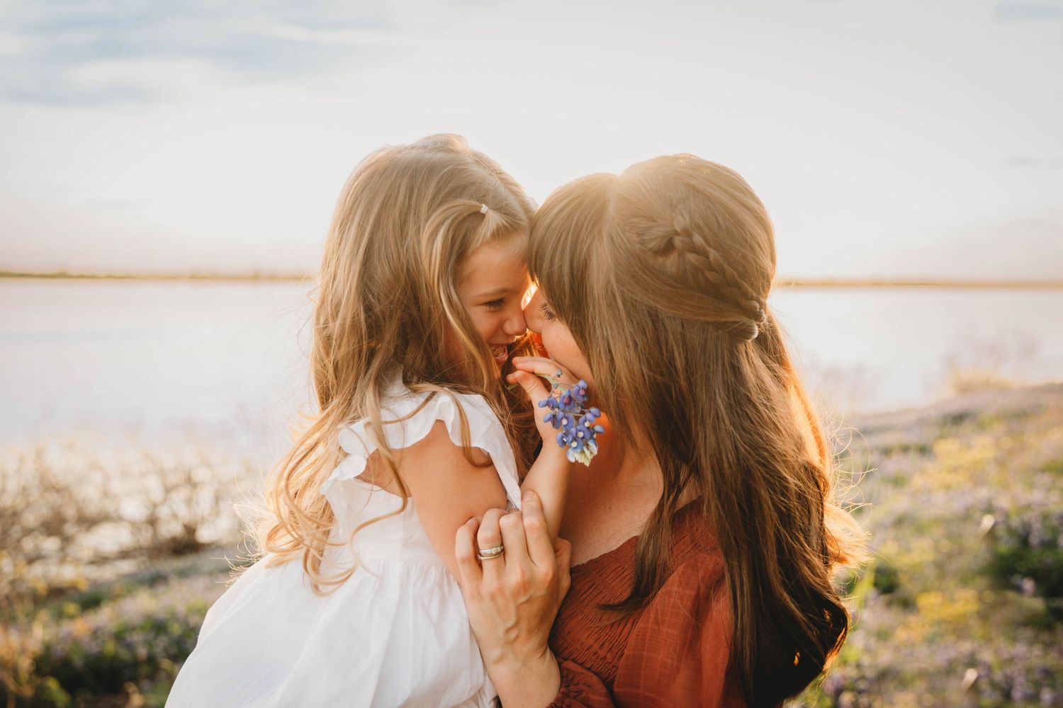 Tender outdoor moment captured against a scenic waterfront background.