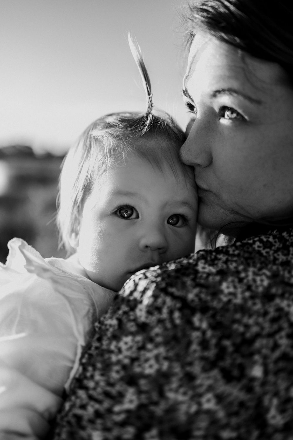 Close-up black and white portrait capturing intimate moment between parent and child.