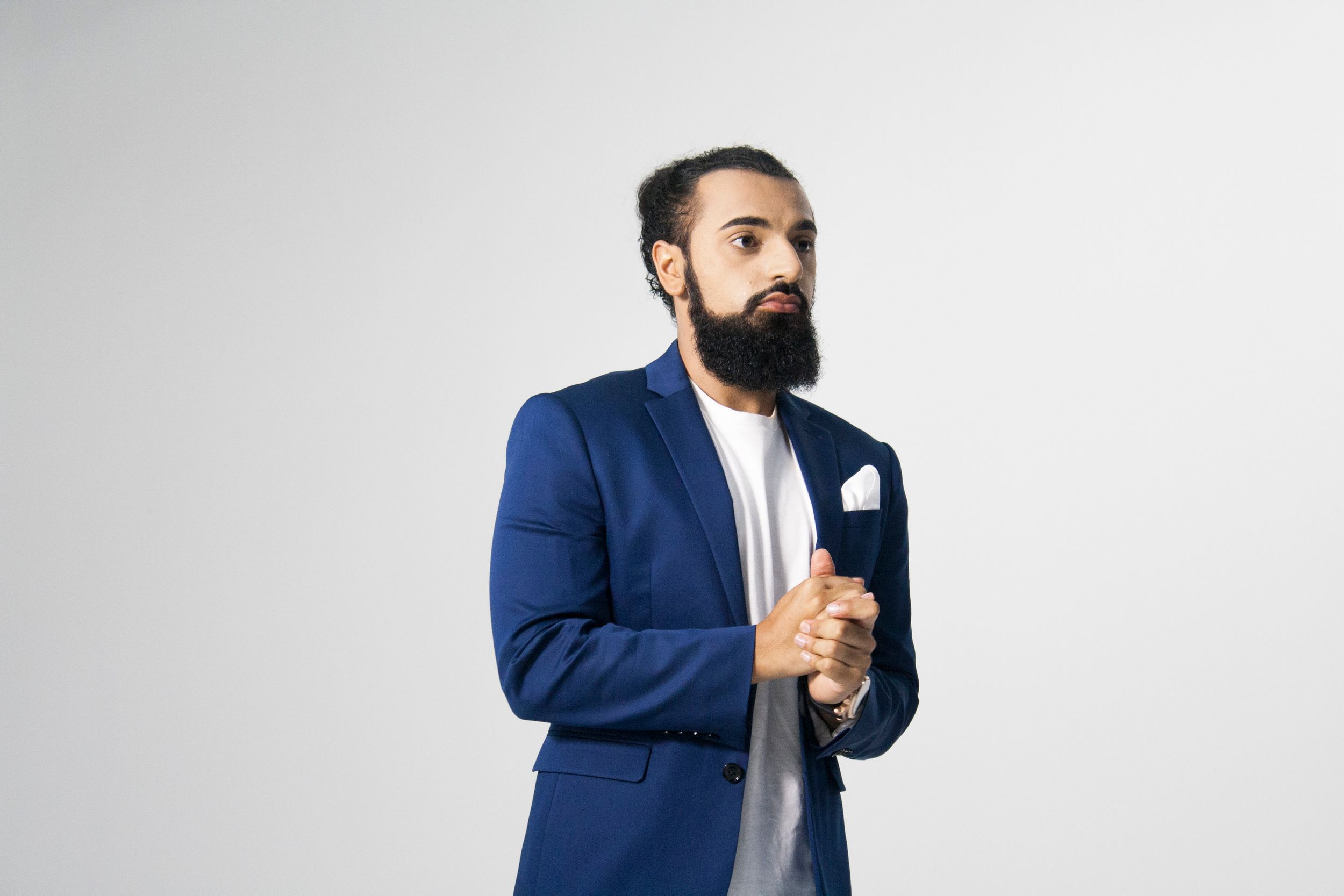Professional wearing a navy blue suit jacket poses against white background in multiple shots showing different angles.