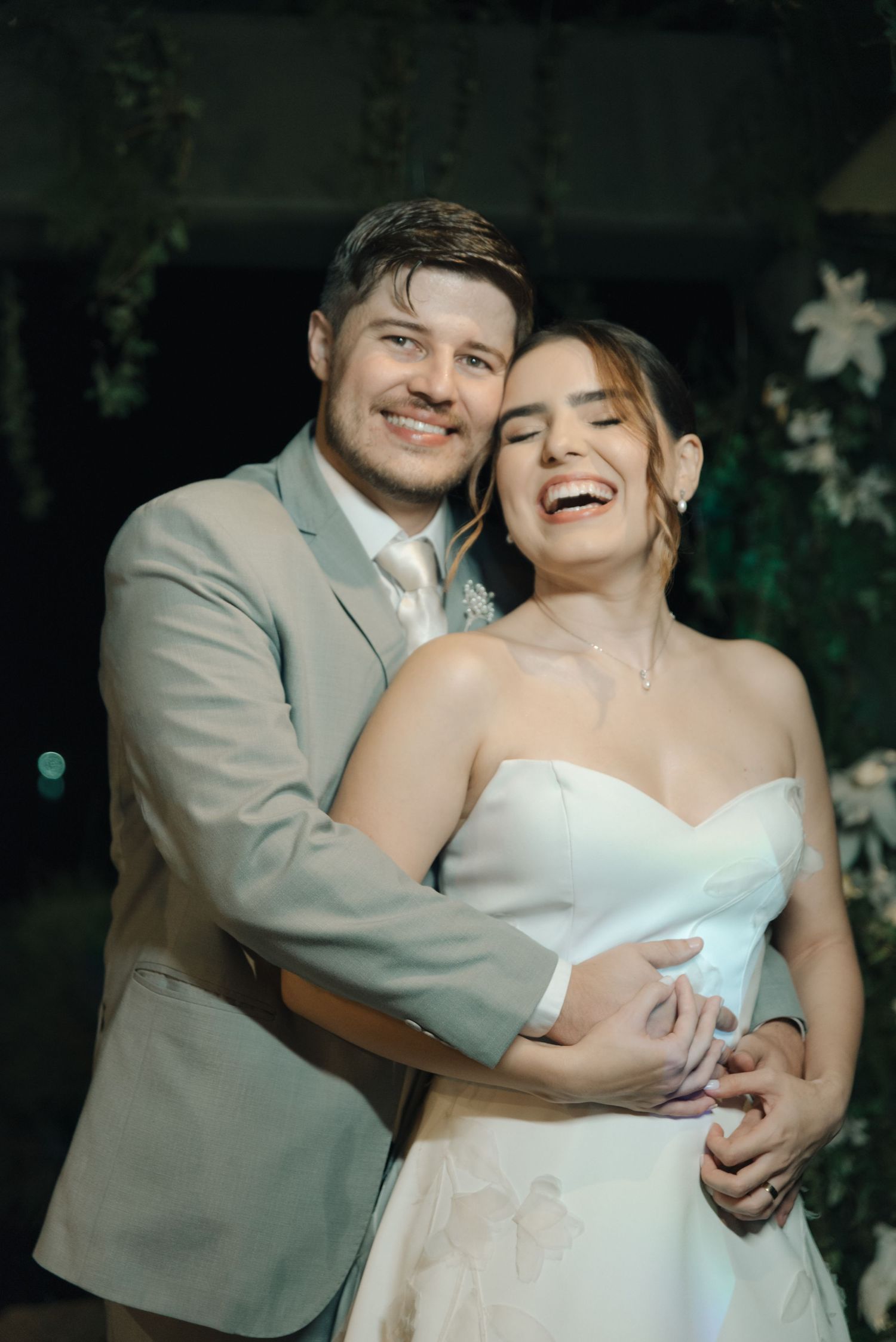 Candid moment of newlyweds laughing together during wedding reception.