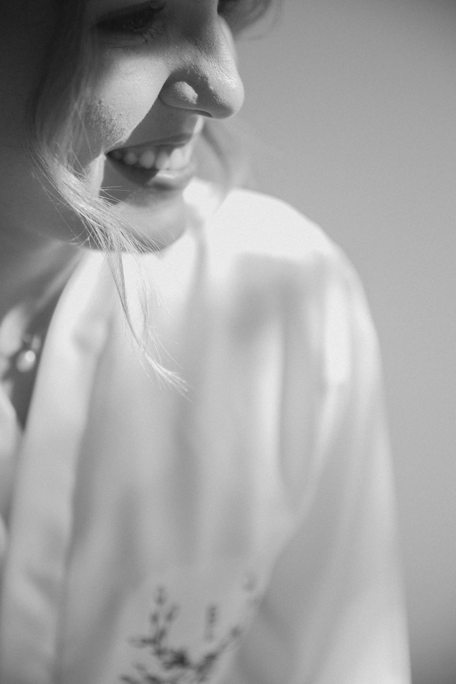 Close-up black and white portrait showing gentle smile and white robe.