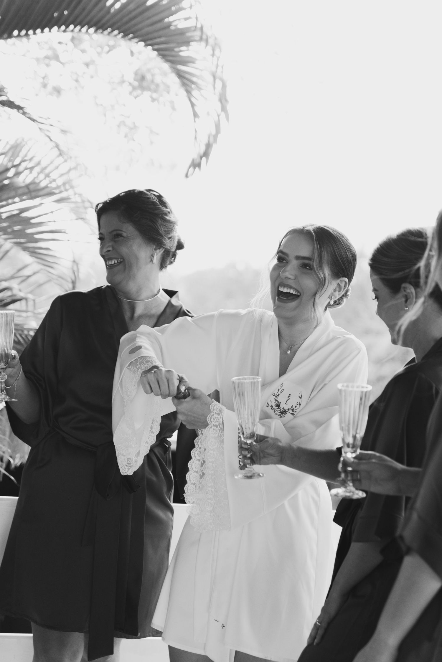 Natural black and white moment of celebration during wedding preparations.