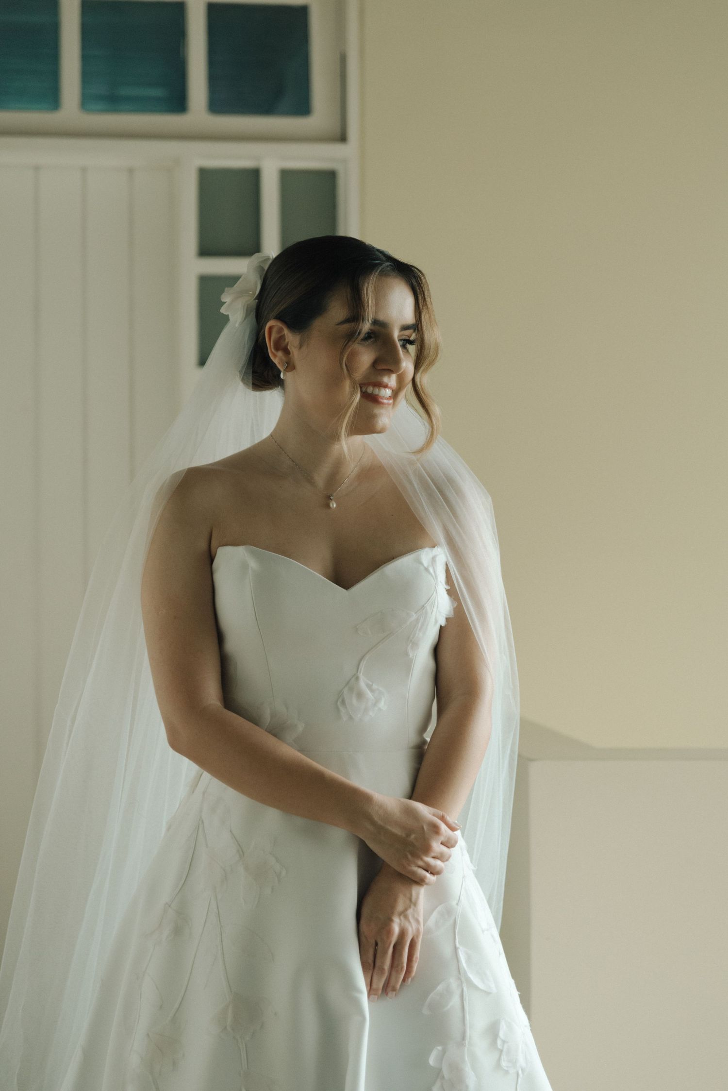 Elegant strapless wedding dress shown in natural window light.