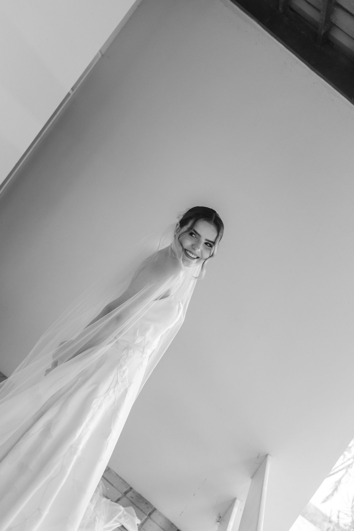 High angle black and white portrait of a bride in wedding dress and veil.