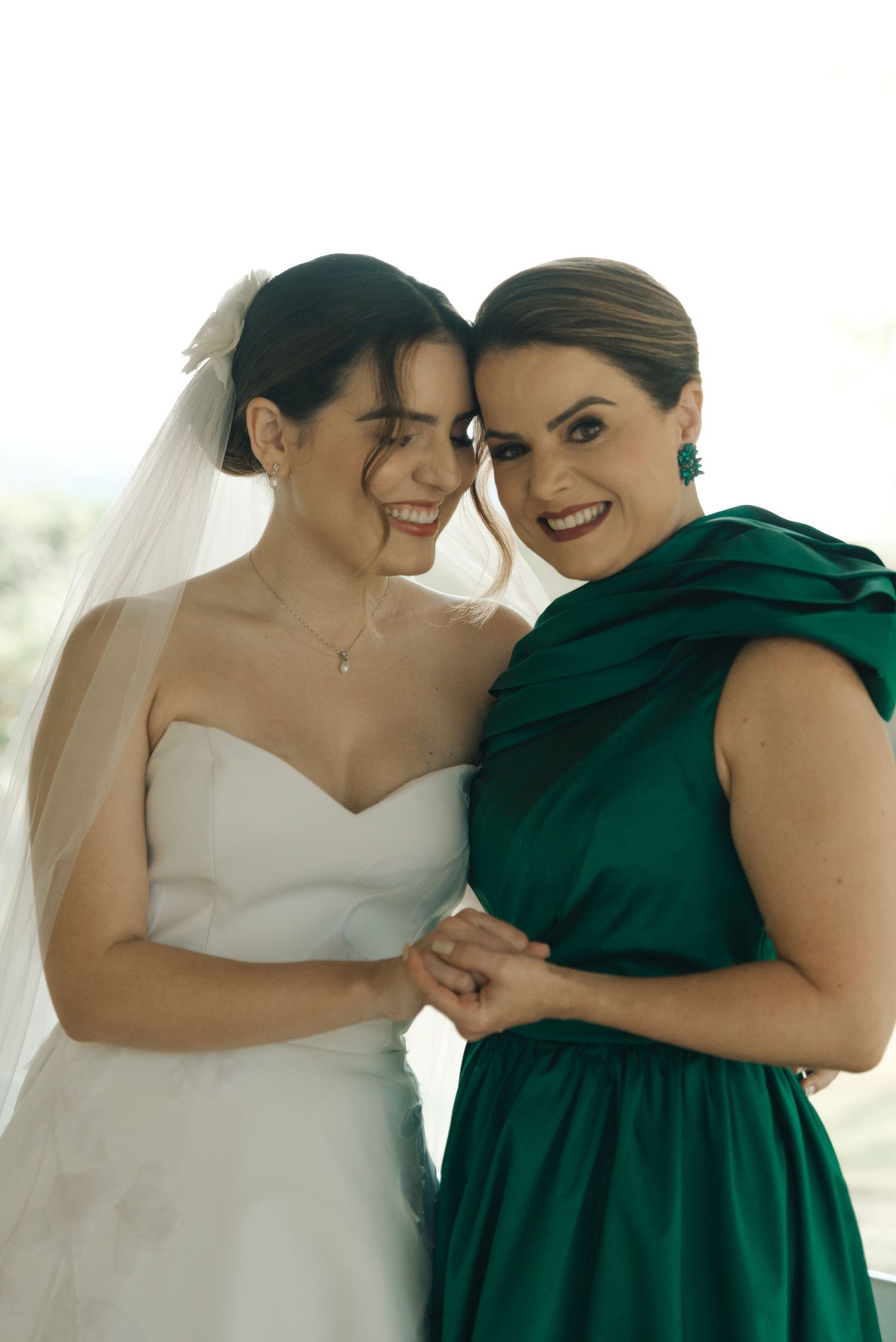 A wedding moment captured with attendees in white and emerald green attire.