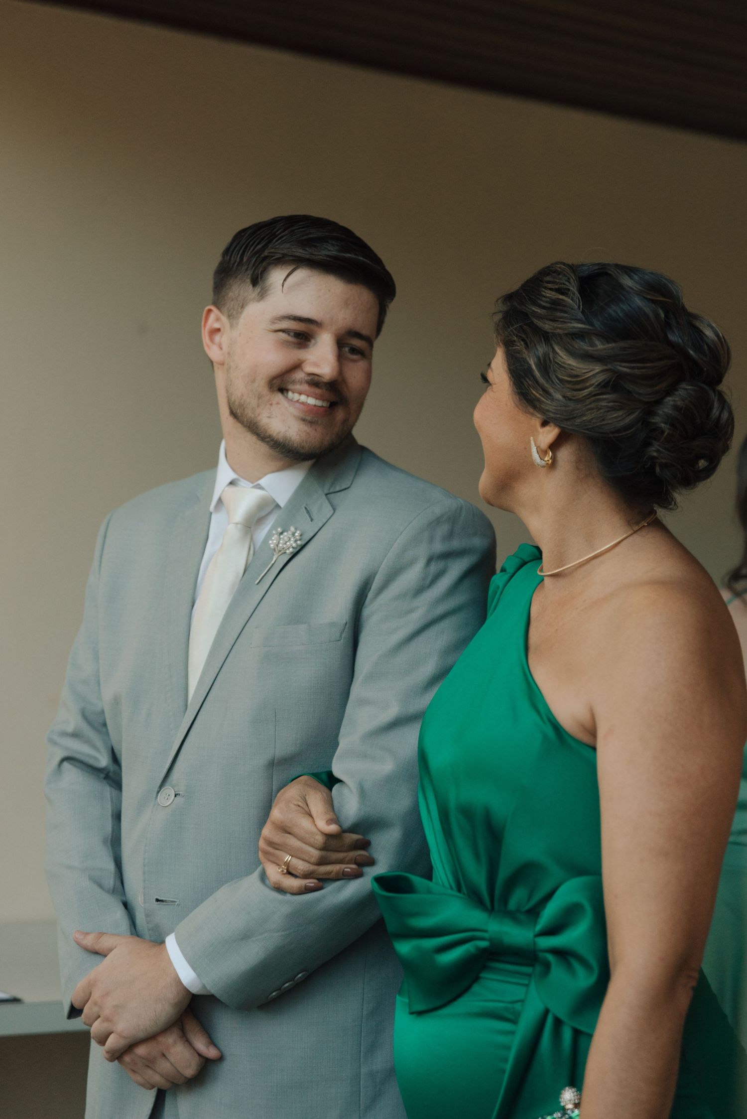 Wedding party members sharing a candid moment in formal attire.