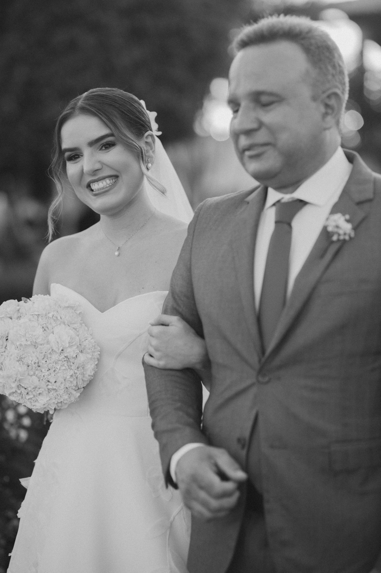 An emotional moment captured during a wedding ceremony on a decorated outdoor pathway.