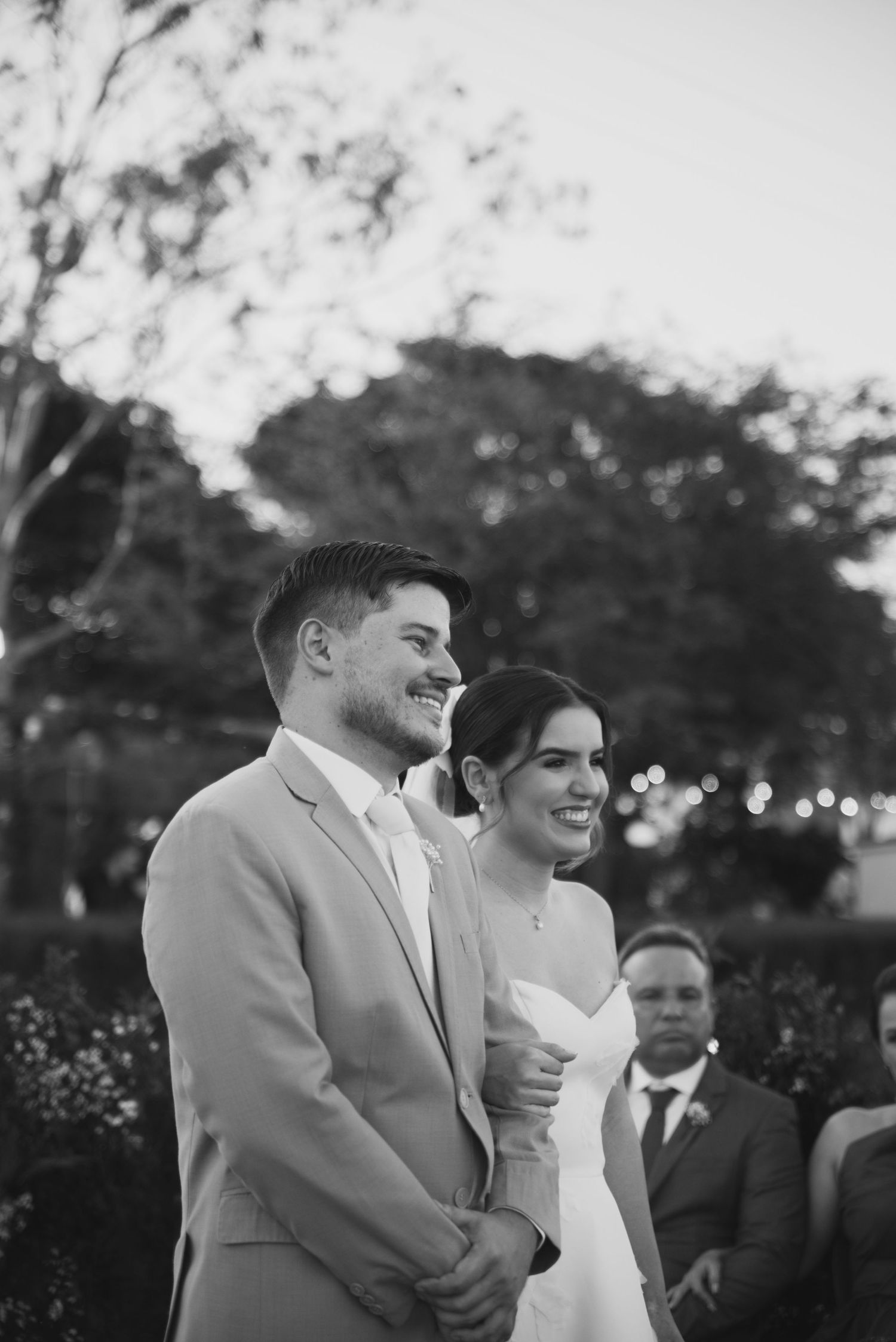 Black and white photograph of a couple during their outdoor wedding ceremony.