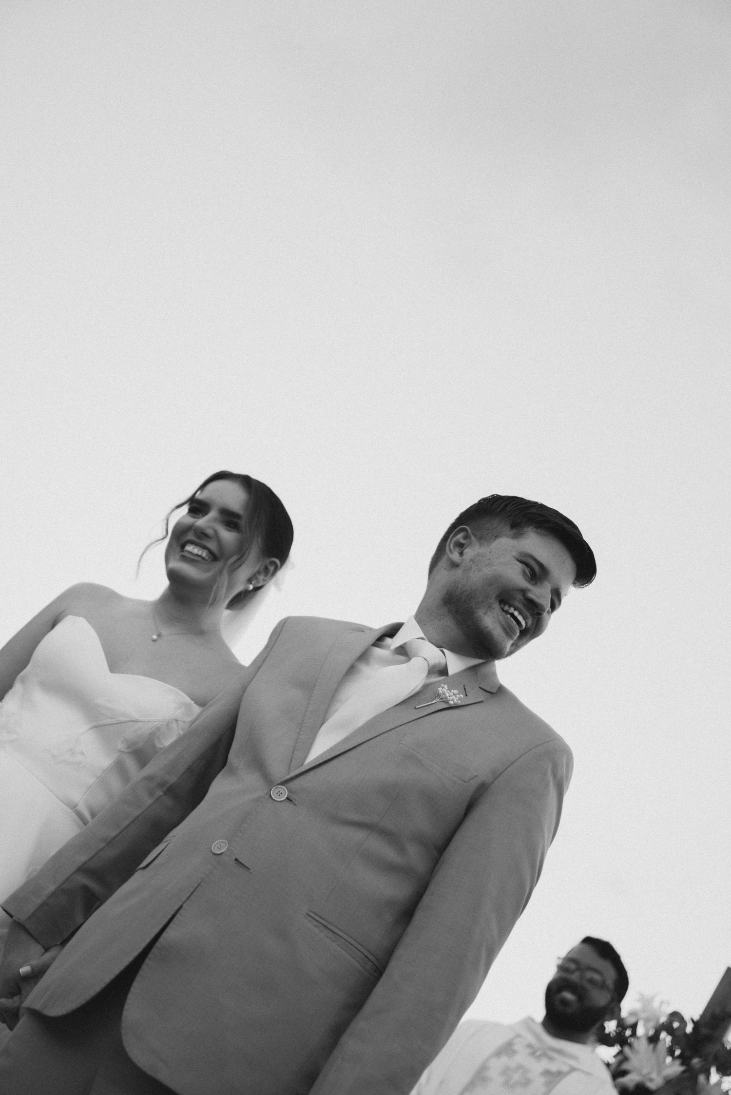 A happy couple laughing together during their outdoor wedding celebration.