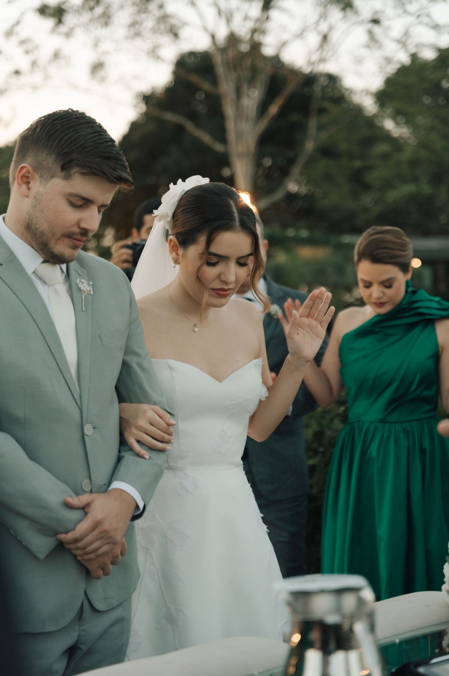 A wedding ceremony in progress with attendants in emerald green dresses.