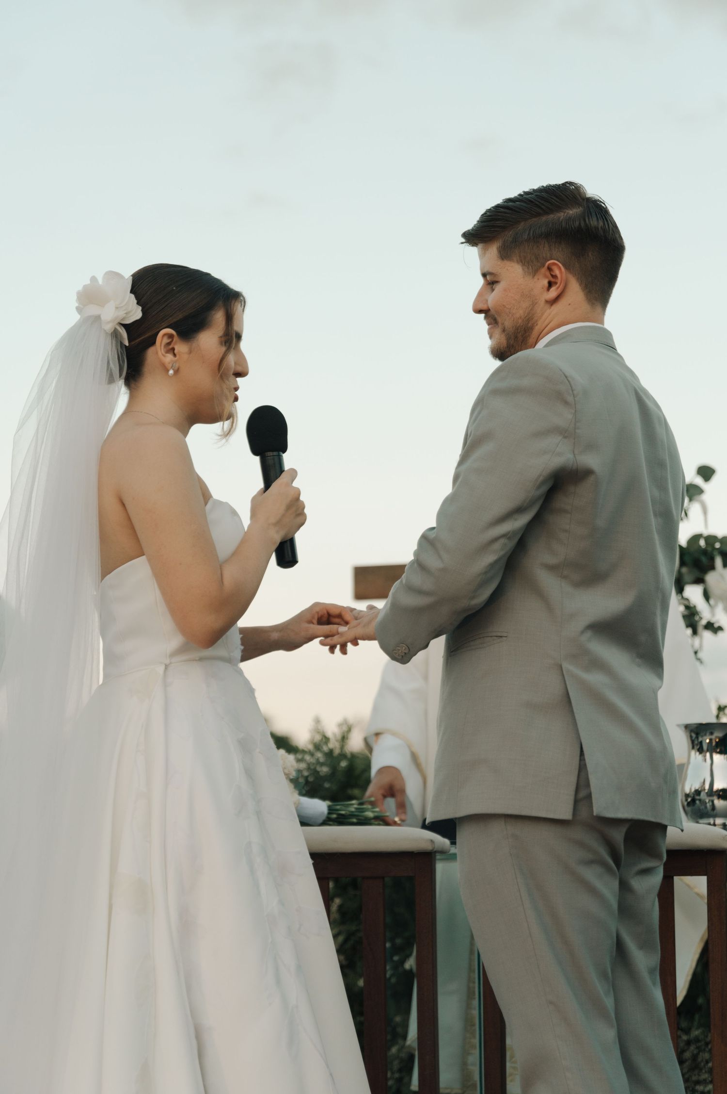A couple exchanges vows during their outdoor wedding ceremony.