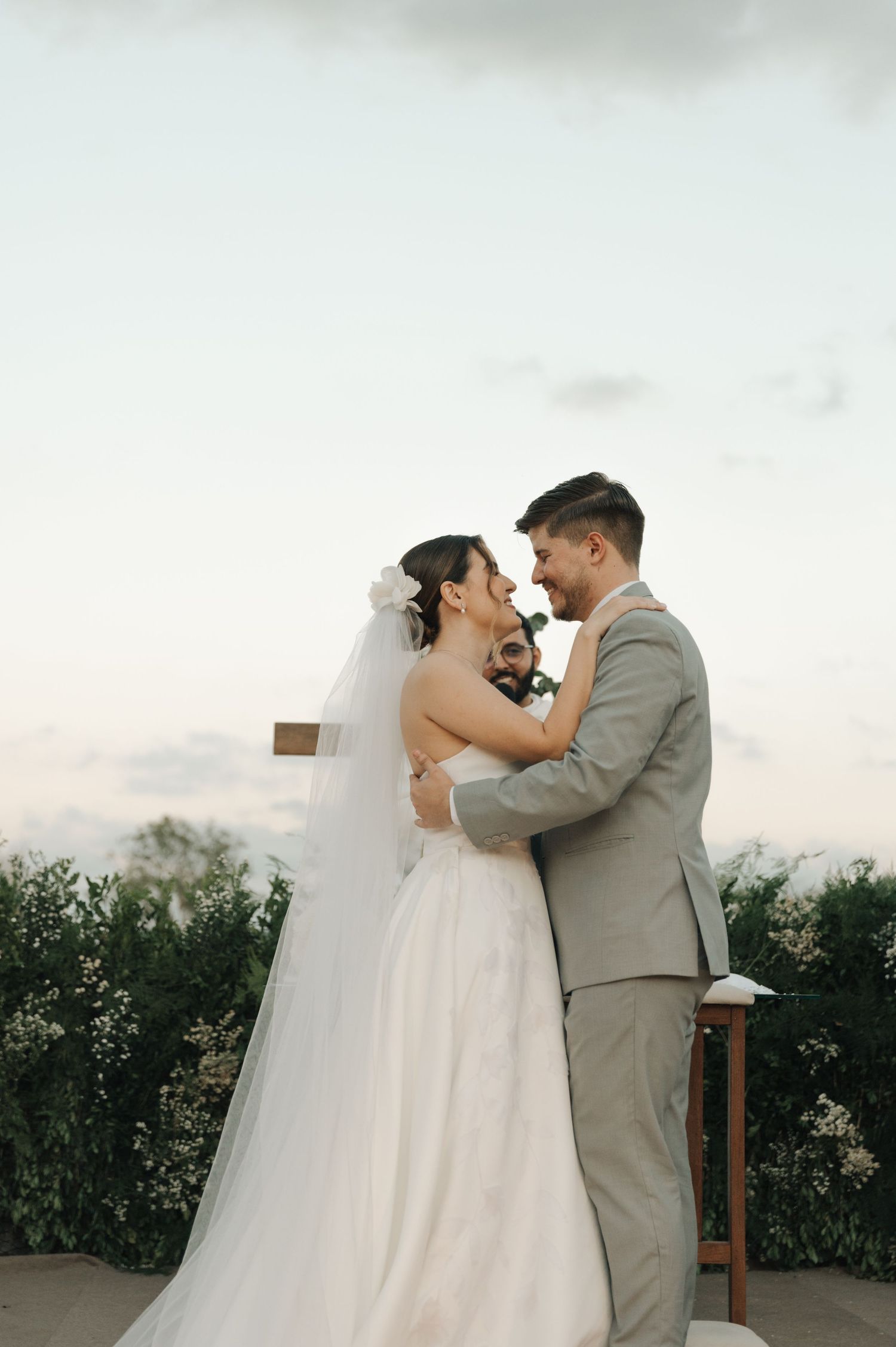 Newlyweds share an intimate moment during their sunset outdoor wedding ceremony.
