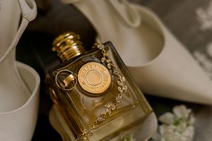Elegant gold perfume bottles arranged on a white surface with soft lighting and reflective surfaces.