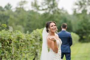 Joyful moment captured in a sunny vineyard during a wedding celebration.