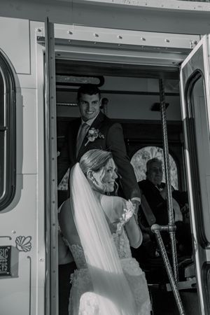 A couple sharing their first kiss as newlyweds inside a train car.