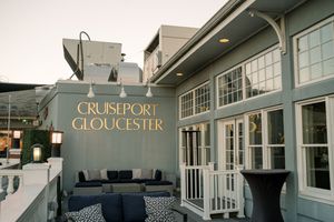 Exterior signage of Cruiseport Gloucester venue with modern architecture and outdoor seating area.