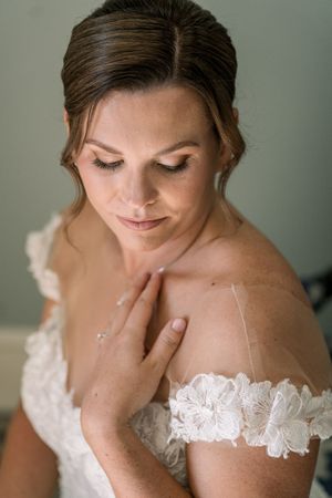 A bride in a delicate white lace gown with off-shoulder details is shown in a series of soft, romantic portraits.