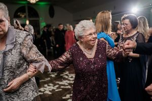 Elderly couples sharing intimate dances together at an evening wedding celebration.
