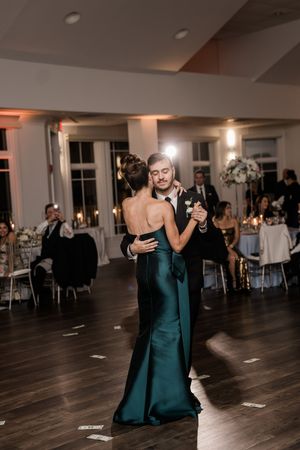 Wedding reception dance floor scene with couples dancing in formal attire under indoor lighting.
