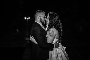 Dramatic black and white nighttime portrait of couple sharing intimate dance moment.