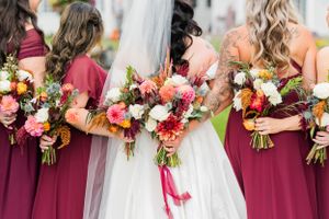 Romantic outdoor wedding portrait featuring navy suit and white dress with colorful fall bouquet.