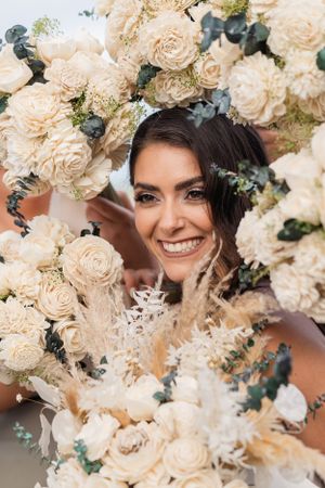Close-up shot framed by cream roses and greenery at an elegant wedding celebration.